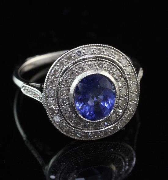 An 18ct white gold, sapphire and diamond cluster target ring, size M.